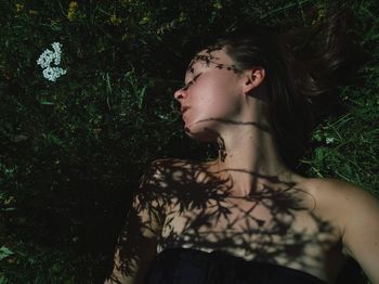 High angle view of woman lying amidst plants outdoors