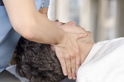 Midsection of woman giving massage to man in beauty spa