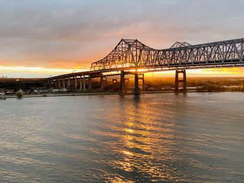 Bridge over river against sky during sunset