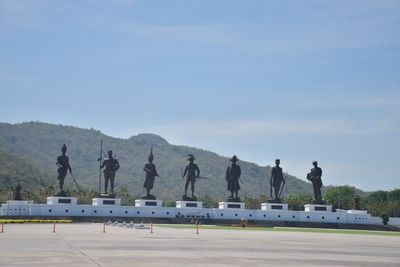 Group of people on airport runway against sky