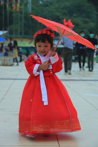 Full length of a boy with red umbrella