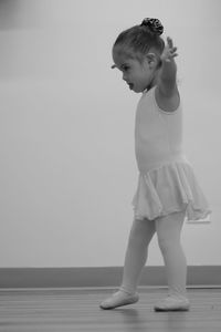 Ballerina girl dancing on floorboard at ballet studio