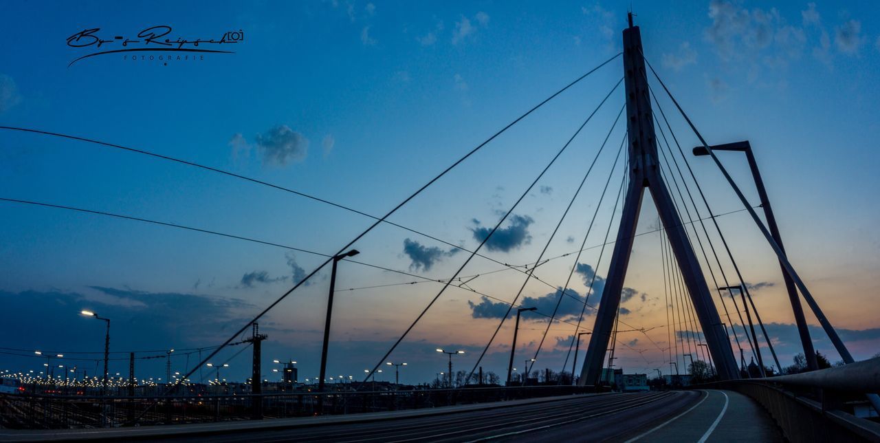 VIEW OF BRIDGE OVER ROAD AGAINST SKY