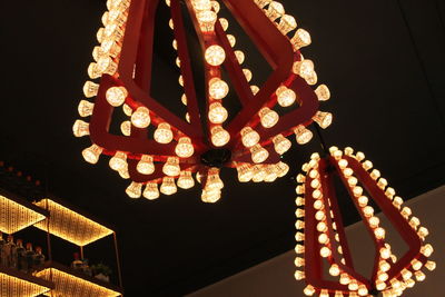 Low angle view of illuminated lanterns hanging at night