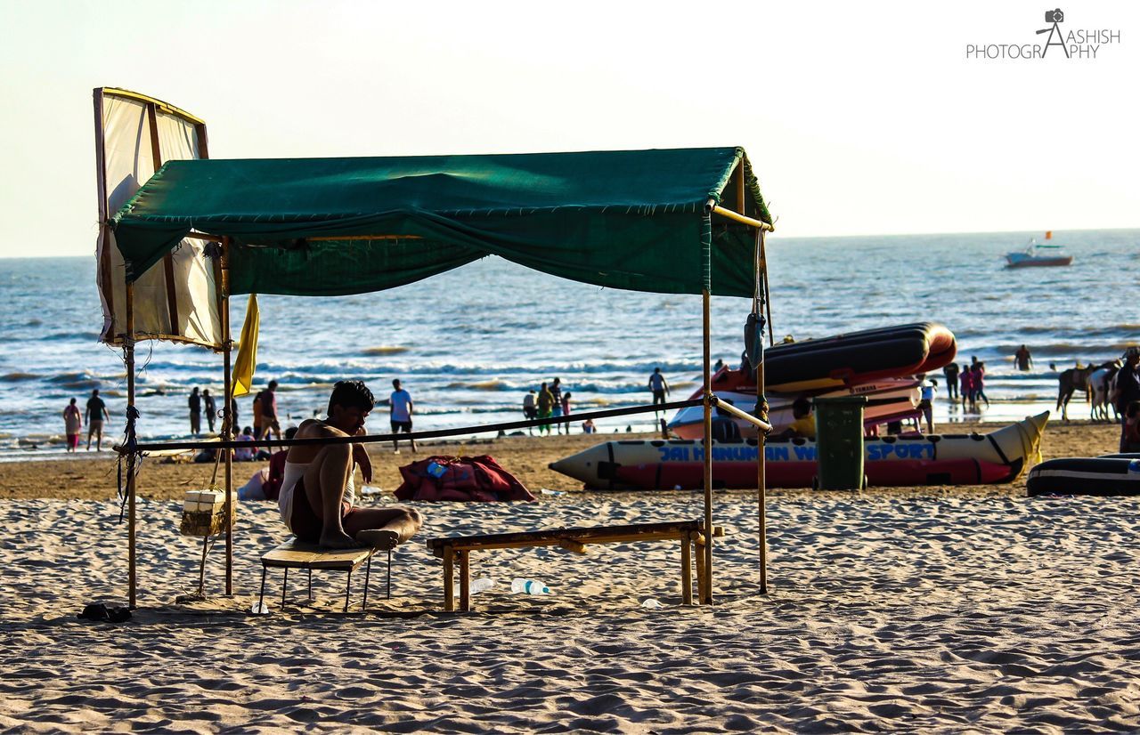 LOUNGE CHAIRS ON BEACH AGAINST SKY