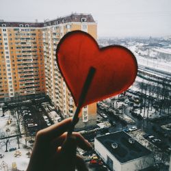 Close-up of hand holding red built structure