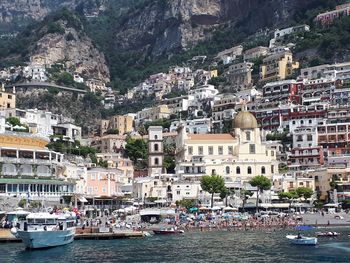 Boats moored in sea by town