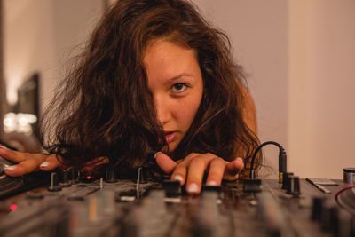 Close-up of fashionable young woman playing music at home