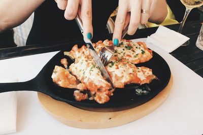 Midsection of woman having food at table