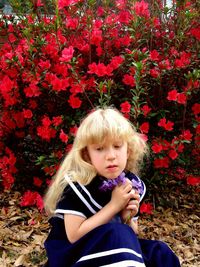 Girl holding flower against plants