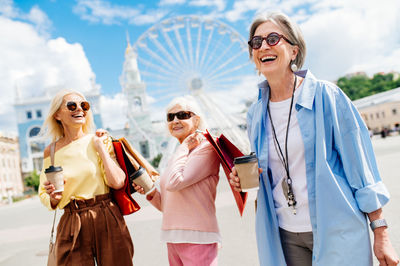 Portrait of female friends standing against sky