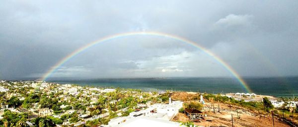 Scenic view of rainbow over city against sky