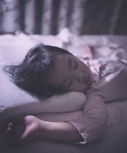 Close-up of baby sleeping on bed at home