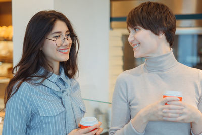 Smiling women holding coffee cup