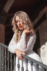 Beautiful woman standing by railing outdoors