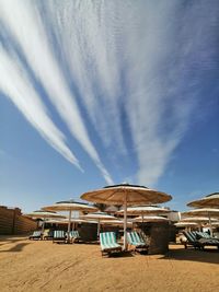 Lifeguard hut on beach against blue sky