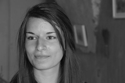 Close-up of smiling young woman looking away at home