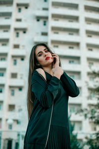 Beautiful young woman standing against built structure