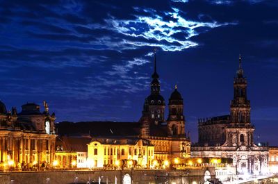 Illuminated buildings in city against sky at night