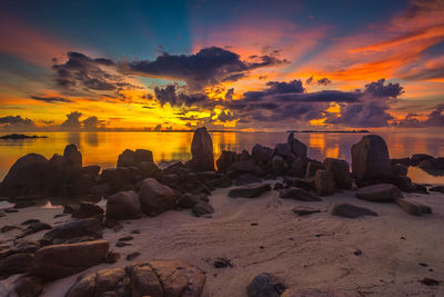View of rocks on beach during sunset