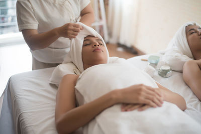 Midsection of masseuse giving massage to woman at spa