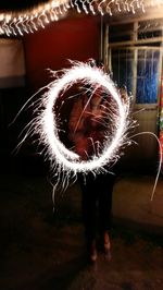 Full length of a girl holding illuminated christmas lights