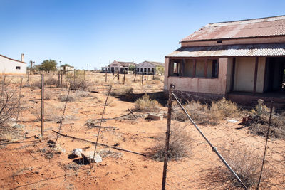 Abandoned building on field against clear sky