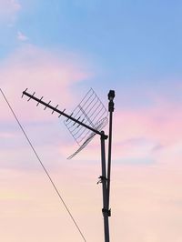 Low angle view of silhouette telephone pole against sky during sunset