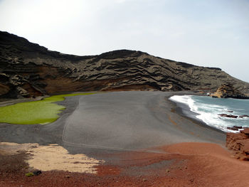 Scenic view of sea and mountains against sky