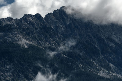 Low angle view of snowcapped mountains against sky