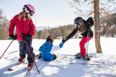 Family skiing on snow covered field