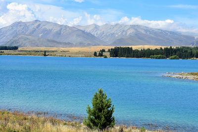 Scenic view of landscape and mountains against blue sky