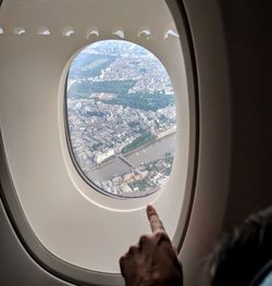 Cropped image of woman pointing in airplane