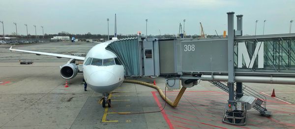 Airplane on airport runway against sky