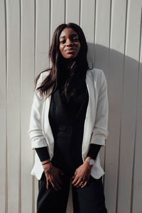 Young woman standing against wall