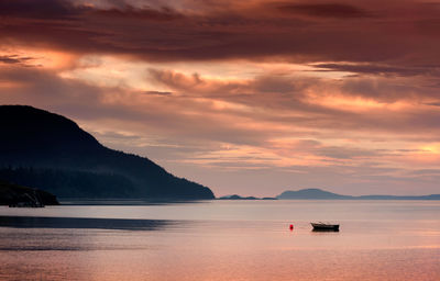 Scenic view of sea against cloudy sky during sunset