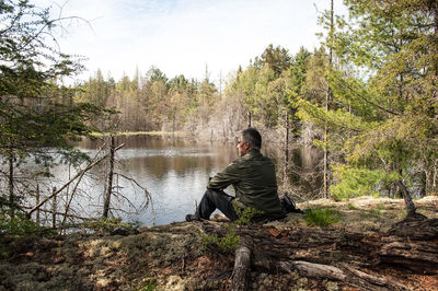 Man sitting by river in forest