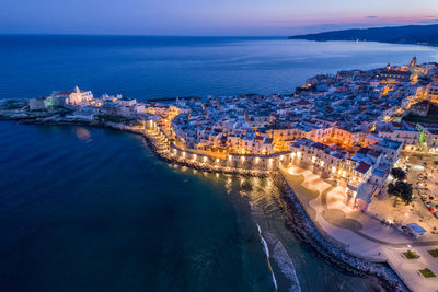 High angle view of city by sea against sky