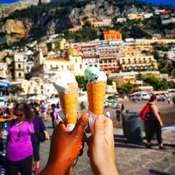 Midsection of person holding ice cream in city