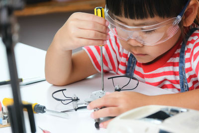 Girl fixing drone at home