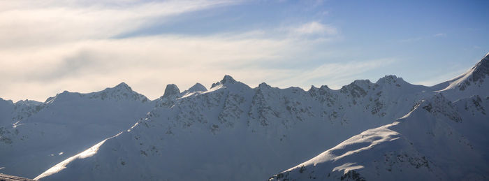Low angle view of snow mountains against sky