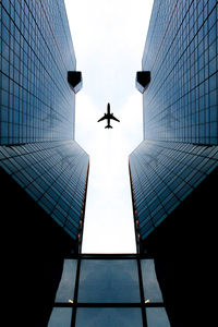 Plane reflected in skyscraper