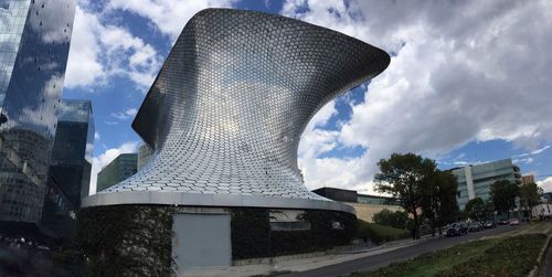 Low angle view of buildings against cloudy sky