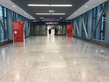 Woman walking in illuminated corridor