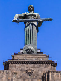 Low angle view of statue against clear blue sky