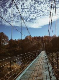 Bridge amidst trees against sky