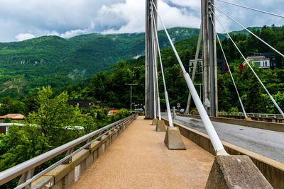 Bridge amidst trees against sky