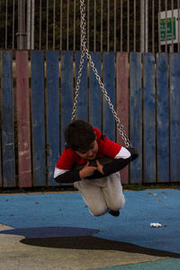 Low section of woman sitting on swing at playground