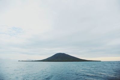 Scenic view of sea and mountains against sky