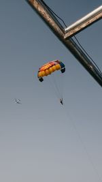 Low angle view of person paragliding against sky